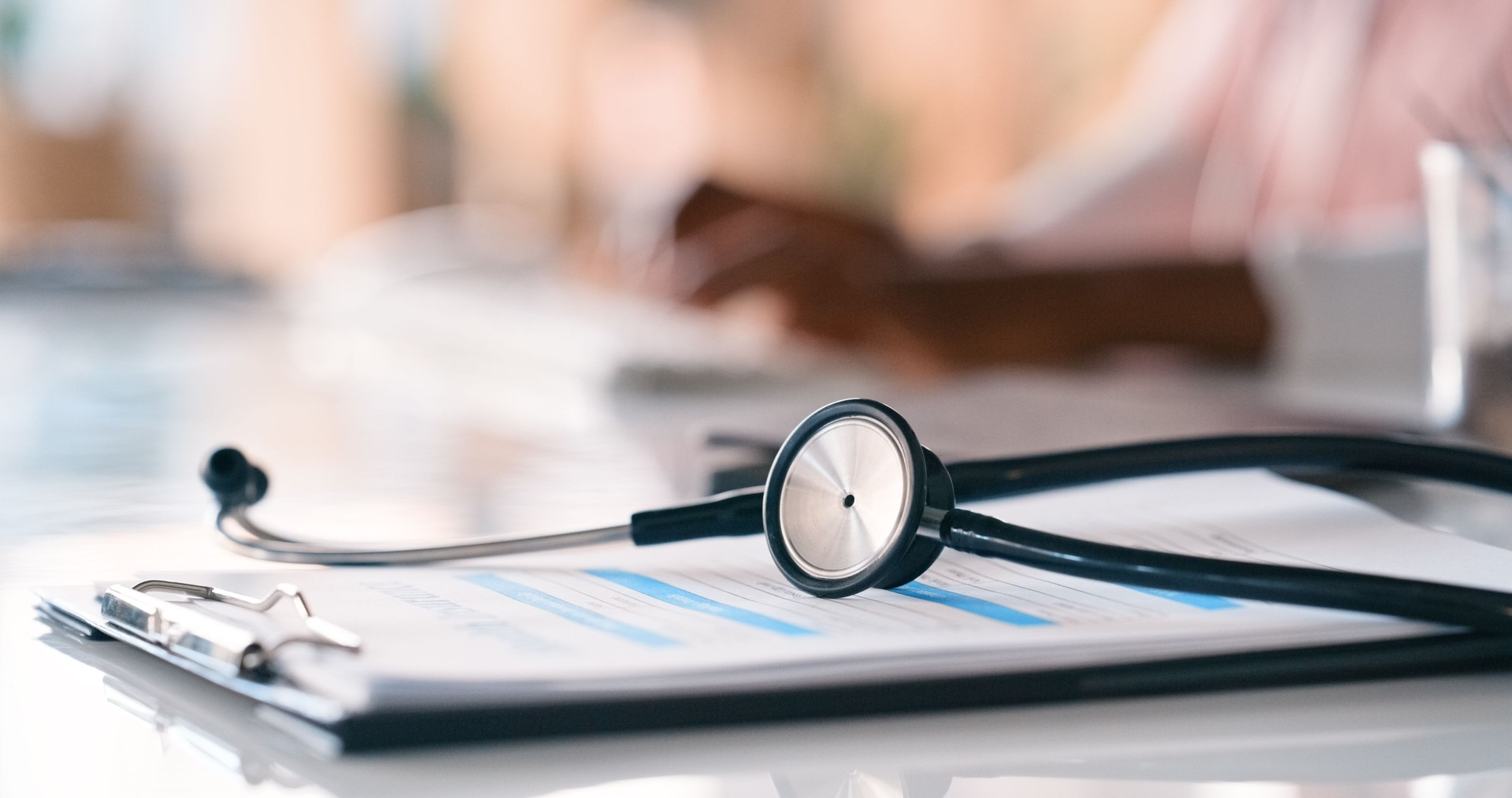 Doctor, contract and insurance with stethoscope for policy, survey or application form at hospital. Closeup of equipment, paperwork or documents for cardiology, healthcare or wellness on clinic desk